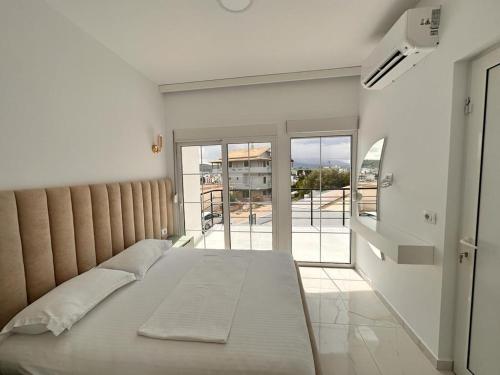 - une chambre avec un lit et une grande fenêtre dans l'établissement Vila SUN 2E, à Ksamil