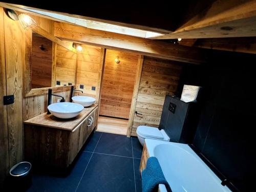 a bathroom with two sinks and a toilet at Appartement dans chalet de luxe Megève in Megève