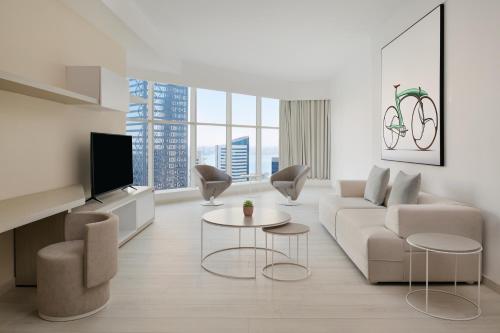 a living room with a couch and chairs and a tv at Element by Westin West Bay Doha in Doha