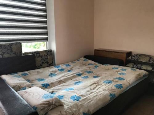 een bed met blauwe bloemen in een slaapkamer bij Гостевой домик на берегу Рижского залива in Bigauņciems