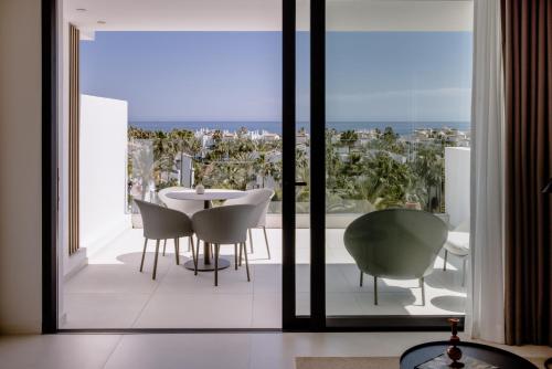 a dining room with a table and chairs on a balcony at THE FLAG HOTEL Marbella, Estepona Adult Recommended in Estepona