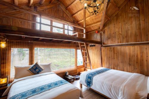 two beds in a room with wooden walls at Legend Home Sapa in Sa Pa