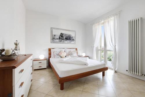 a white bedroom with a bed and a large window at Katy Lake 2 in Desenzano del Garda