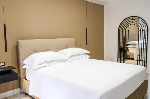 a bedroom with a white bed and a mirror at Aroma Apartment, Maschio Angioino-Porto Di Napoli in Naples