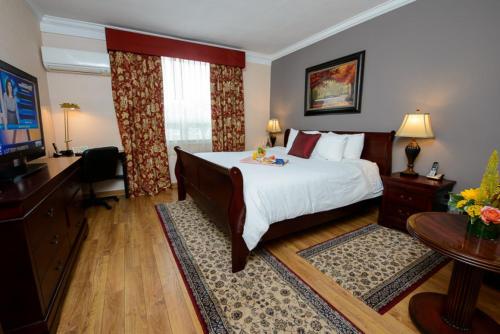 a hotel room with a large bed and a television at Norwalk Inn & Conference Center in Norwalk