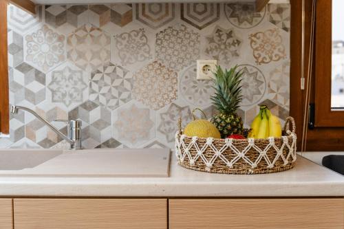 a basket of fruit sitting on a counter next to a sink at NaxosAir1 in Naxos Chora