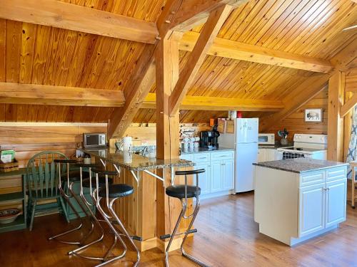 una cucina con elettrodomestici bianchi e soffitto in legno di Spacious Salmon River Waterfront Lodge for 6 a Altmar