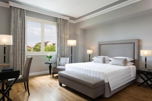 a bedroom with a large white bed and a window at Sina Villa Medici, Autograph Collection in Florence