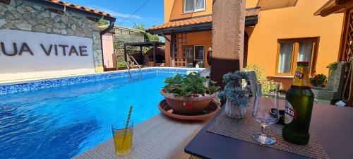 Bed & Breakfast Villa Adriana في بريمونتيرا: طاولة مع زجاجة من النبيذ بجوار حمام السباحة