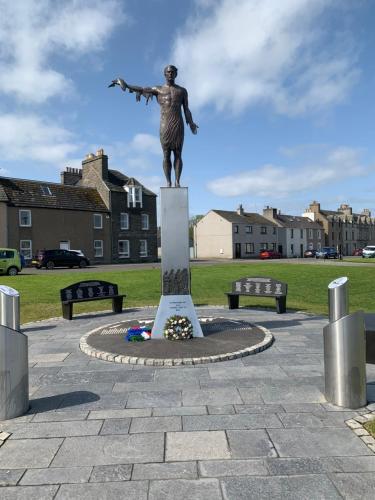 Una estatua de una mujer parada sobre un pedestal en un parque. en Harbour View, en Wick