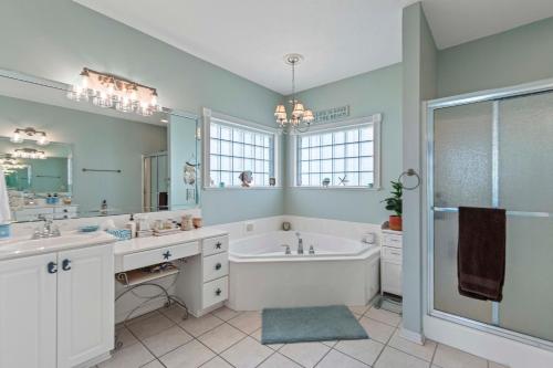a bathroom with a tub and a sink and a shower at Gratitude Island in Navarre