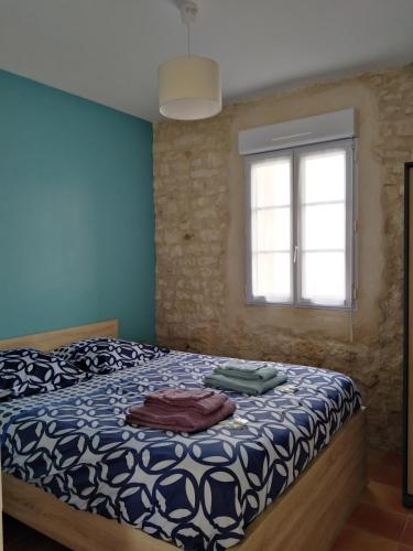 a bedroom with a bed and a window at La Flottille, La Cotinière in La Cotinière