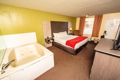 a hotel room with a bed and a bath tub at River Place Inn in Pigeon Forge