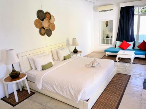 1 dormitorio con 1 cama blanca grande y 1 sofá azul en Dreams Villa - Double Six Beach en Seminyak