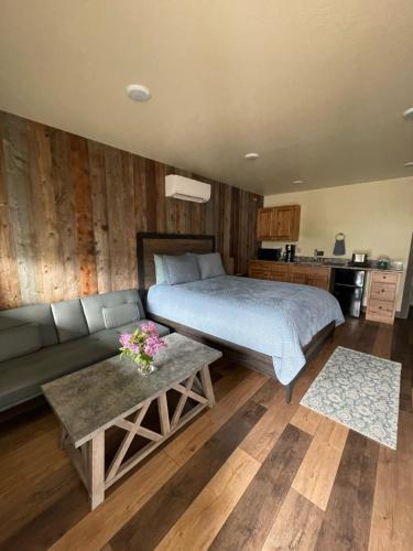 1 dormitorio con cama, sofá y mesa en Rhodopa Lodge at Yellowstone, en Gardiner