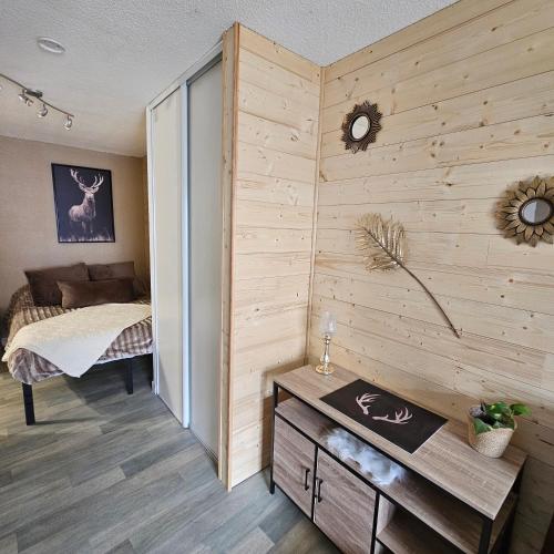 une chambre avec un lit et un mur en bois dans l'établissement Appartement centre-ville, à Font-Romeu-Odeillo-Via