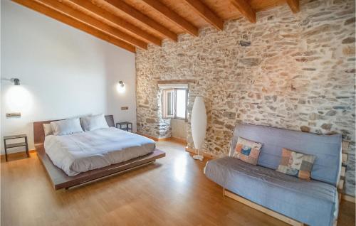 1 dormitorio con cama y pared de piedra en Stunning Home In Saucelle With Kitchen, en Saucelle