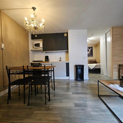 une salle à manger et une cuisine avec une table et des chaises dans l'établissement Appartement centre-ville, à Font-Romeu-Odeillo-Via