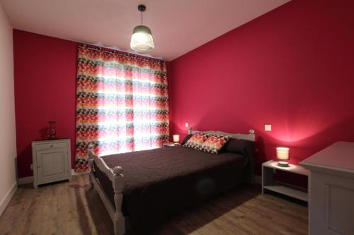 een slaapkamer met een bed en een rode muur bij Iduzki-alde bi in Souraïde