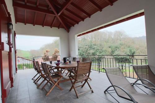 een veranda met een tafel en stoelen op een balkon bij Iduzki-alde bi in Souraïde