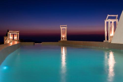 a swimming pool at night with the lights on at Galaxy Suites & Villas in Imerovigli