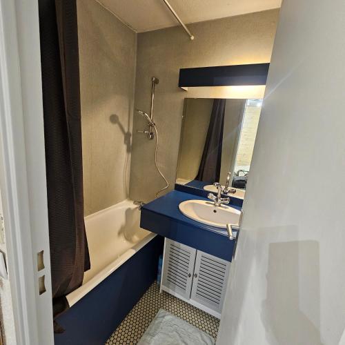 une salle de bain avec un lavabo, un miroir et une baignoire dans l'établissement Appartement centre-ville, à Font-Romeu-Odeillo-Via