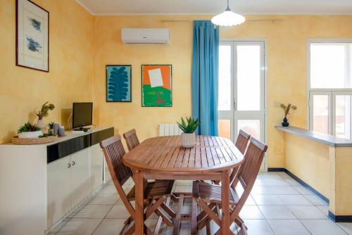 a dining room with a wooden table and chairs at [Torregrande]APT.3 - Vicino al mare - Free Wi-Fi in Torre Grande