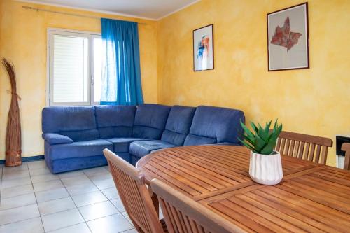 a living room with a blue couch and a table at [Torregrande]APT.3 - Vicino al mare - Free Wi-Fi in Torre Grande