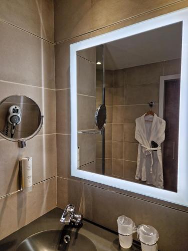 bagno con lavandino e specchio di Hotel Le Saint Paul a Nizza