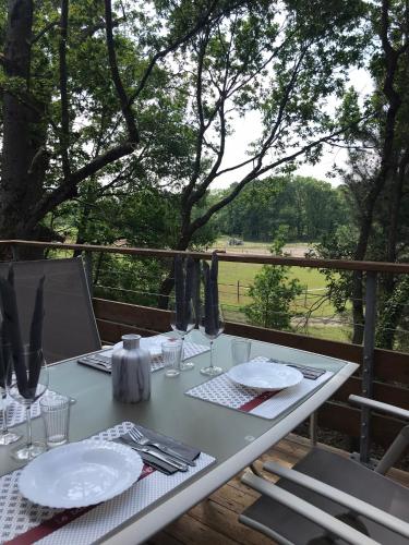 a white table with plates and utensils on a balcony at Eleni appart 4p à Richelieu in Chaveignes
