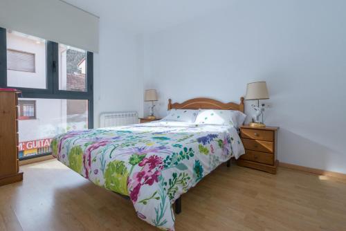 1 dormitorio con 1 cama con un edredón colorido en Vipimmoble !, en Guardiola de Berguedà