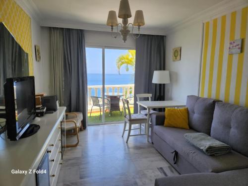 a living room with a couch and a view of the ocean at Fantastic Ocean view apartment Buena Vista with amazing Pools in Acantilado de los Gigantes