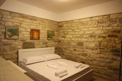 - une chambre avec un lit et des serviettes dans l'établissement Margarita Guest House, à Berat