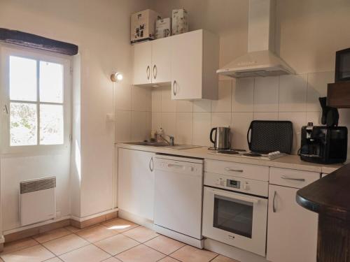 a kitchen with white appliances and a window at Le Castelviel in Albi