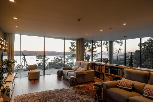 a living room with a large library with large windows at Villa Paladina in Foz do Arelho
