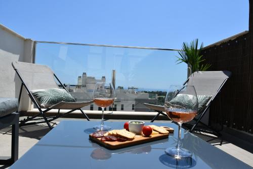 zwei Gläser Wein und ein Tablett mit Essen auf dem Tisch. in der Unterkunft Luxurious flat & private rooftop in Villamartin Orihuela Costa in Orihuela