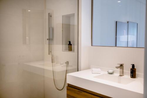 a white bathroom with a shower and a sink at THE FLAG HOTEL Marbella, Estepona Adult Recommended in Estepona