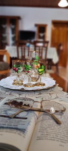 a table with plates and glasses and a book at Theofania's Marble House Meteora in Kastrákion