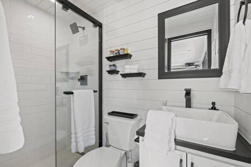 ein Badezimmer mit einem WC, einem Waschbecken und einem Spiegel in der Unterkunft New Wilderness Hideout-Cozy Container Home in Fredericksburg
