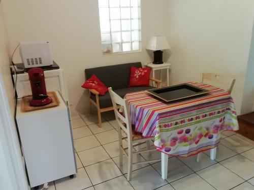 une petite cuisine avec une table et un canapé dans l'établissement Janyjack, à Arsac
