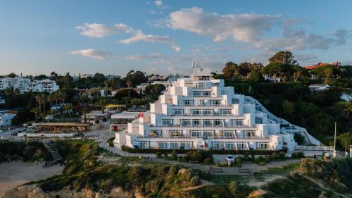 a large white building on top of a hill at Monicca Collection Suites and Residences in Albufeira