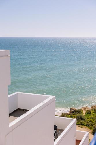 a view of the ocean from the balcony of a house at Monicca Collection Suites and Residences in Albufeira