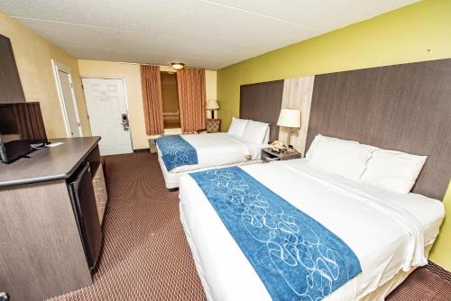 a hotel room with two beds and a flat screen tv at River Place Inn in Pigeon Forge
