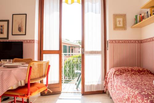um quarto com uma mesa, uma cama e uma varanda em [300 metri dal mare] Relax con aria condizionata em Spotorno