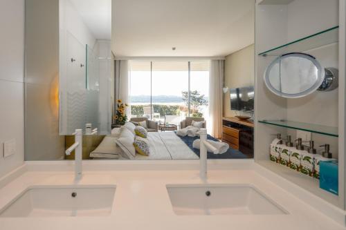 a bathroom with a large mirror and a living room at Villa Paladina in Foz do Arelho