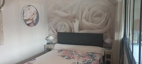 een slaapkamer met een bed en een muur met beeldhouwwerken bij Albi à proximité, maison d'hotes les oliviers in Rosières