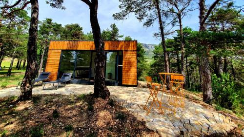 a small cabin in the woods with two chairs at La calade in Bargème