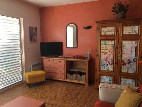 ein Wohnzimmer mit einem TV und einer Kommode in der Unterkunft Chez Marilyn in Rognes