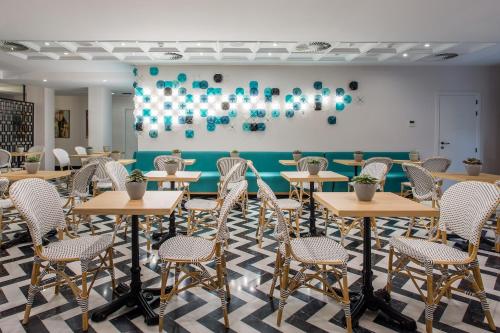 a room with tables and chairs and a wall with balloons at Room Mate Collection Valeria, Málaga in Málaga