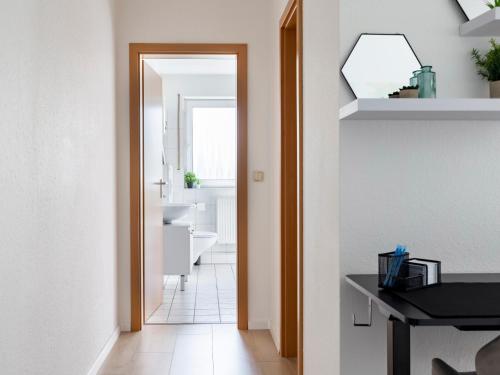 蓋爾森基興的住宿－MICOA: Tiefgarage/Netflix/Highspeed Arbeitsplatz，走廊通往带水槽和镜子的浴室
